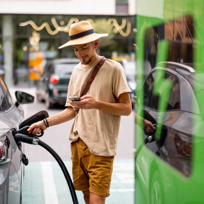 man-charging-electric-car-on-a-public-charging-sta-6DAP47A.jpg